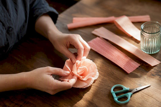 Handen maken een bloem van crêpepapier